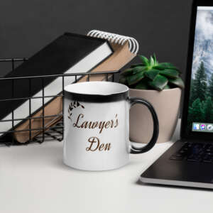 A Lawyer's Den Magic Mug with the words lawyer's dad on it next to a laptop.